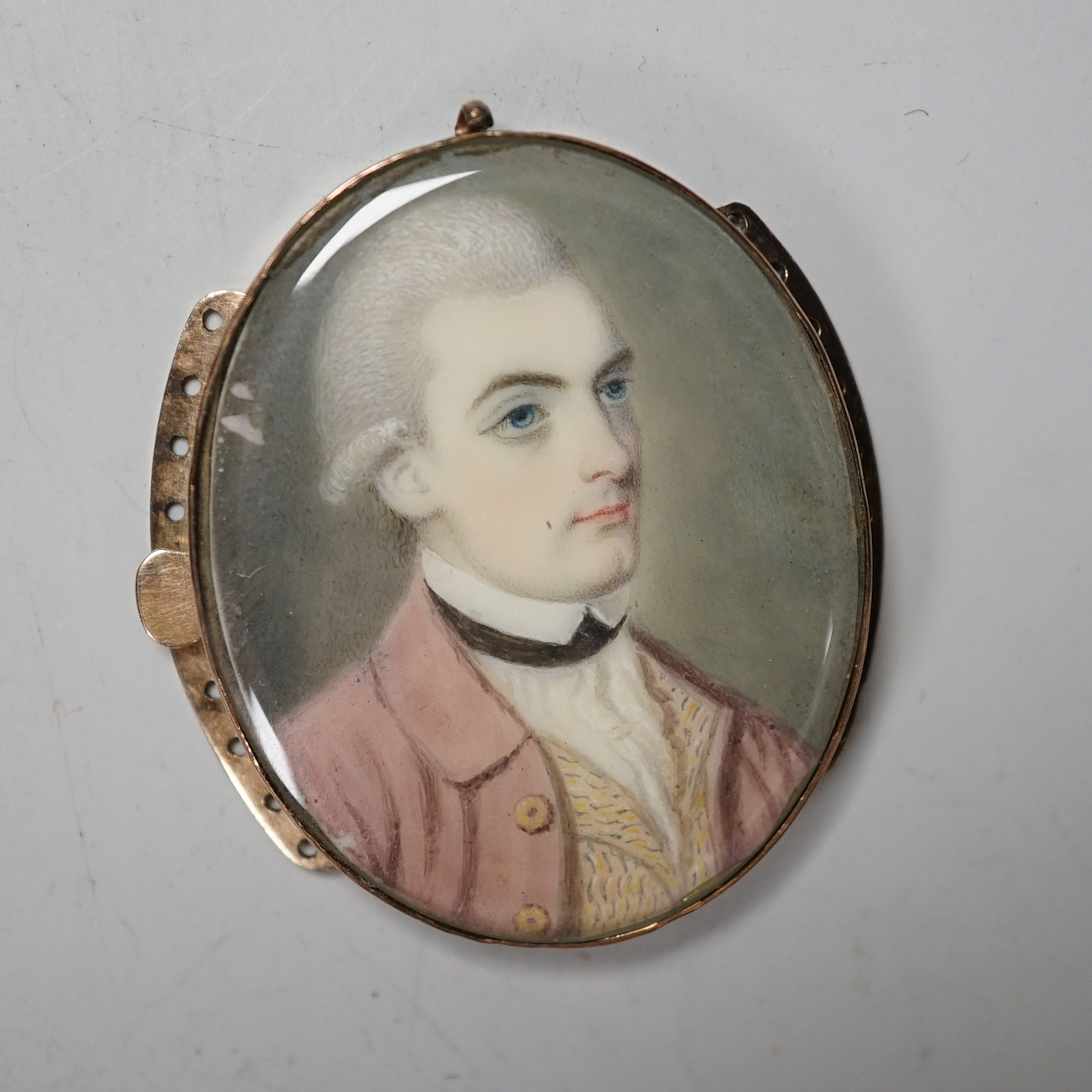 An 18th century oval portrait miniature on ivory of a gentleman wearing a frock coat, housed in a yellow metal mount, 4cm high CITIES submission reference 8D655XW4